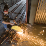Construction worker cutting iron beams in a structure