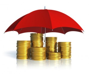 Financial stability, business success and insurance concept: stacked golden coins covered by red umbrella isolated on white background with reflection effect