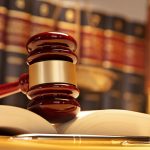 Gavel Resting On Top Of Open Law Book